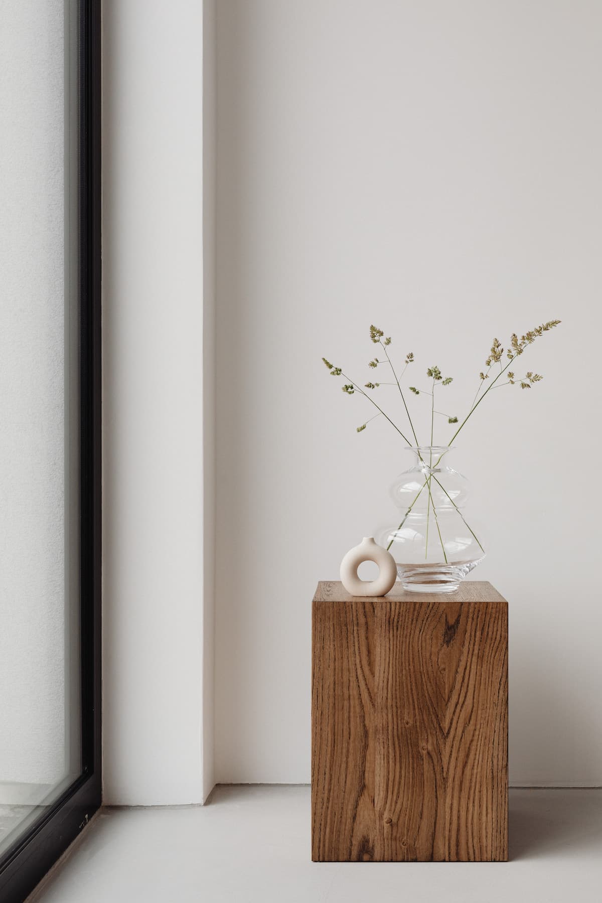 So geht gemütlicher Minimalismus: Holz-Elemente wie dieser Block, auf dem eine schlichte Glasvase steht