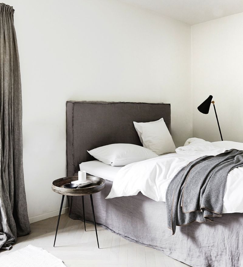 Minimalistisches Schlafzimmer einrichten - Was es dafür braucht: ein behagliches Polsterbett, einen kleinen Seitentisch, eine Leseleuchte. Nicht zu vergessen: hochwertige Bettwäsche und genug Kissen.