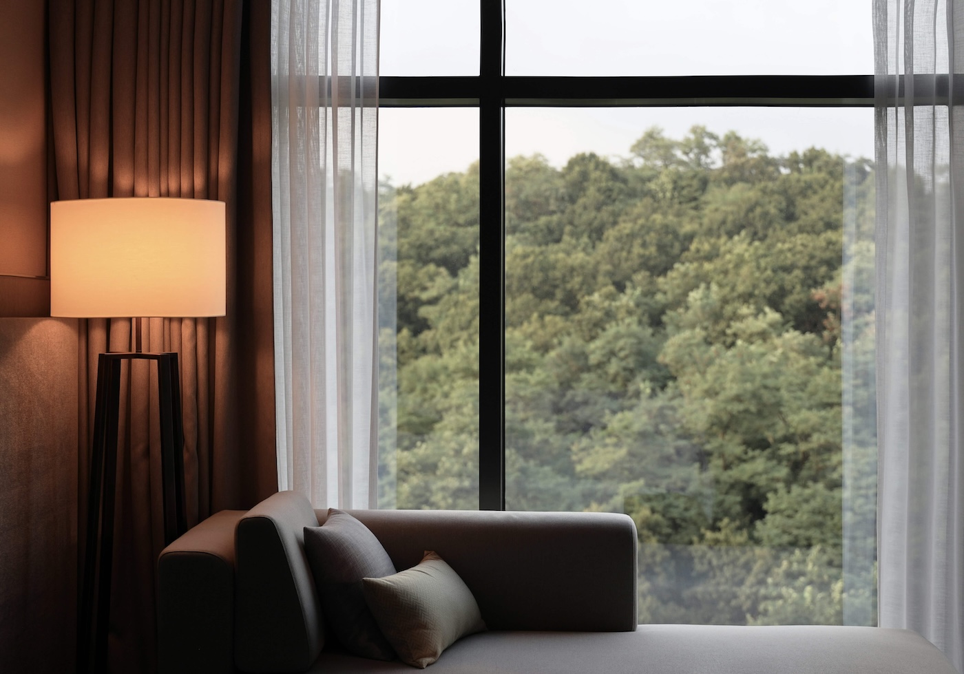 Das Bild zeigt ein Einzelzimmer in einer Klinik, das beusst an zuhause erinnert: Ausblick, warme Farben, angenehmes Licht. Healing Architecture & Healing Environment: Raum für Regeneration, Wohlbefinden und Genesung - ein Zuhause auf Zeit