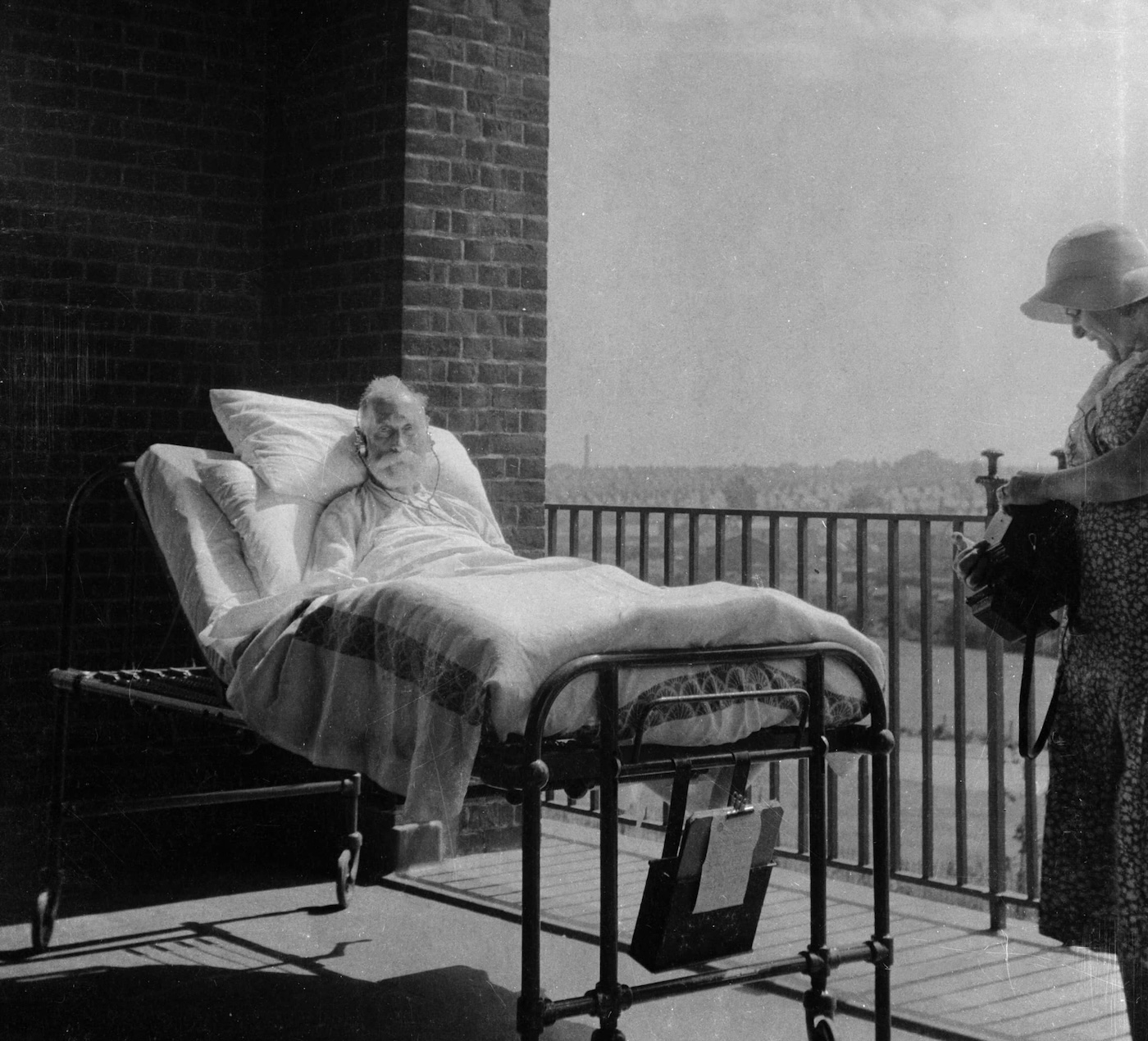 Das Bild zeigt einen alten Mann im Krankenbett auf einem Ballon in der Sonne